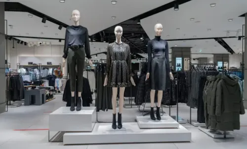 Tienda de moda con maniquíes y prendas organizadas en expositores.