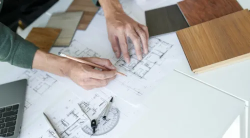 Profesionales trabajando sobre planos técnicos con muestras de madera