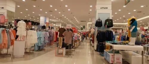 Interior de una tienda de ropa con diferentes secciones y expositores