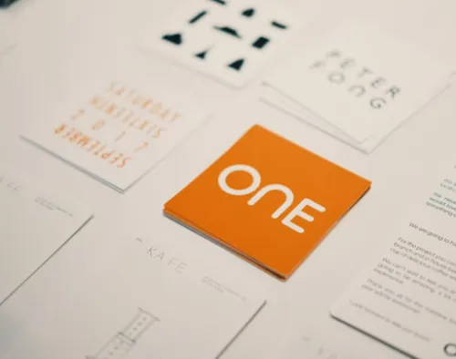 Brand identity materials featuring typography, symbols and an orange colour palette.